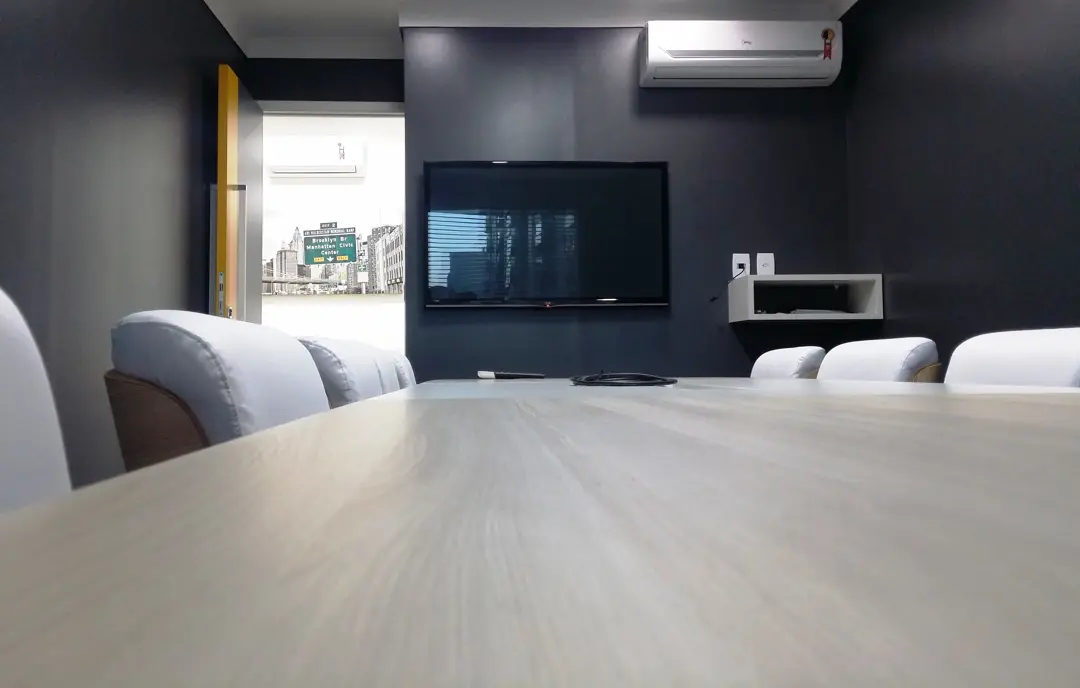 Sala de reunião para 10 pessoas num espaço parceiro em Maceió, com mesa longa e TV na parede