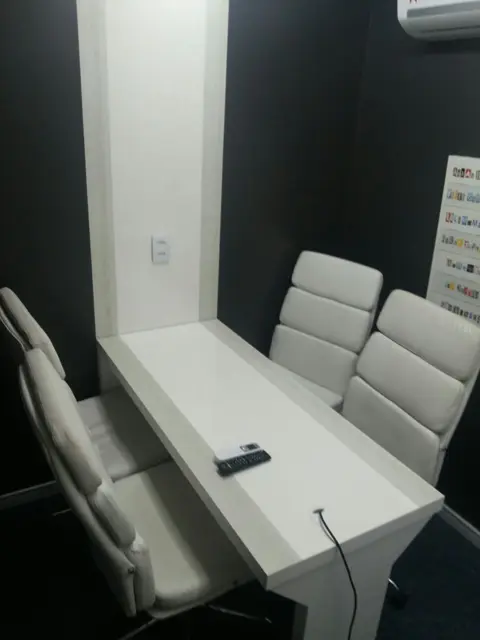 Sala para 4 pessoas com mesa branca e cadeiras